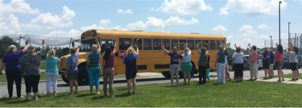 Teachers waving to school bus